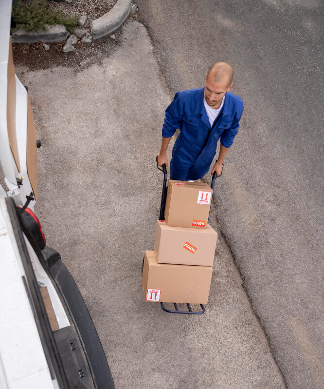 Full shot delivery man carrying boxes